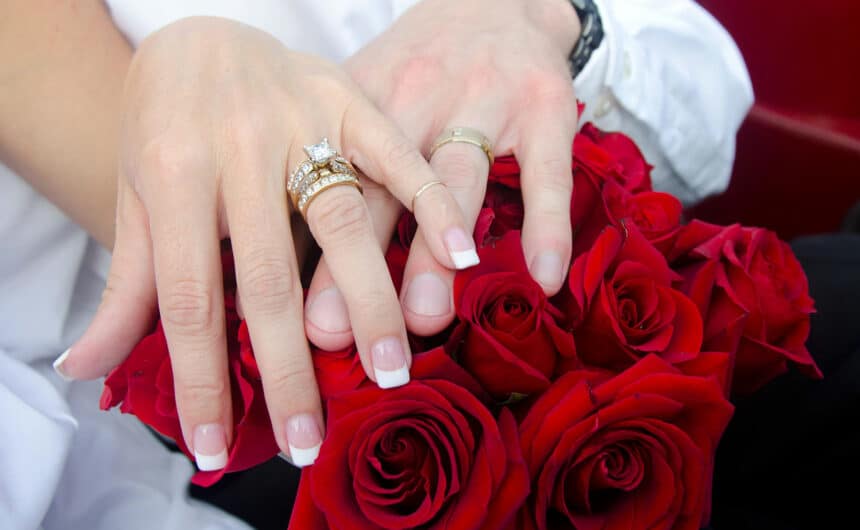 hands on the roses with wedding rings on